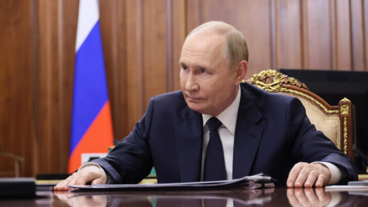 Wladimir Putin, the president of Russia, sitting behind a big desk.